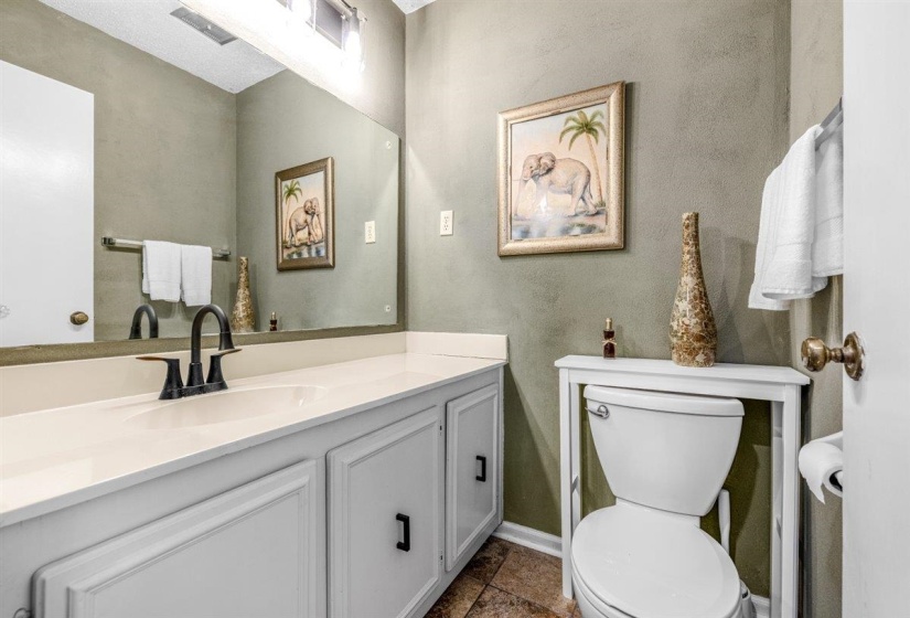 Bathroom featuring a white vanity with integrated sink, black matte faucet, and matching cabinet hardware