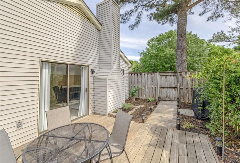Private rear deck with wood plank flooring, sliding glass door access to the interior, and a fenced perimeter