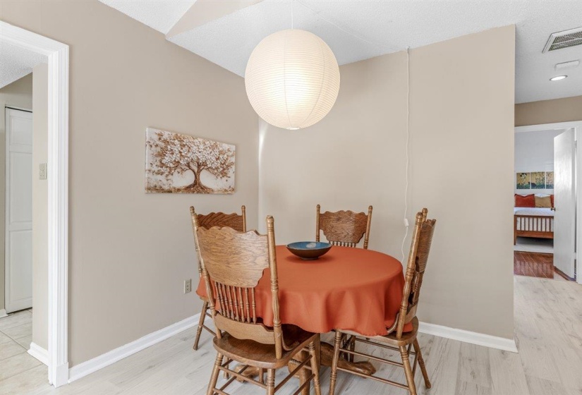 Dining area featuring a paper globe pendant light fixture, light wood-finish flooring, and neutral wall tones