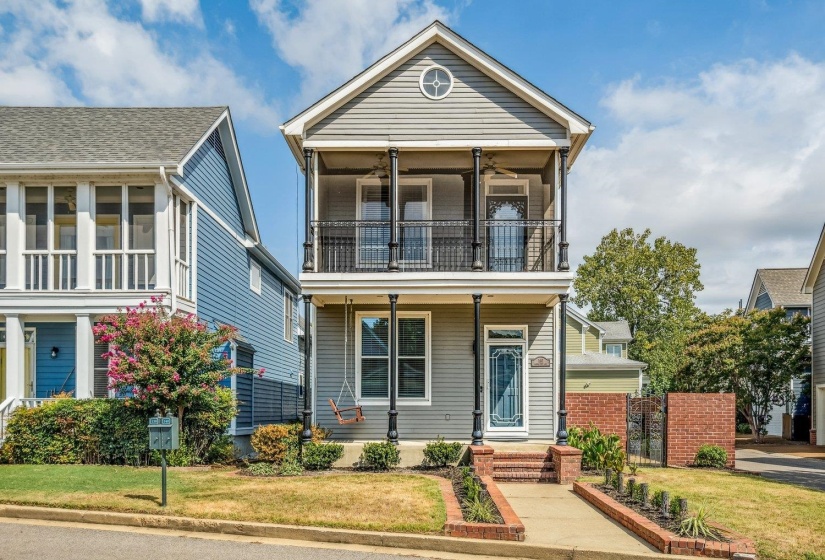 View of front of house with ceiling fan and a balcony