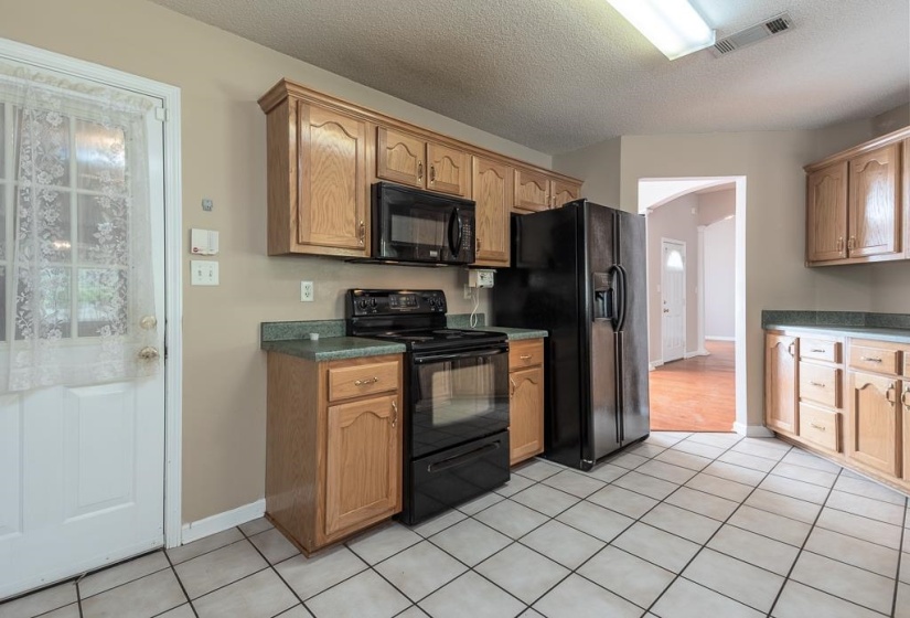 Kitchen featuring light wood cabinetry and black appliances