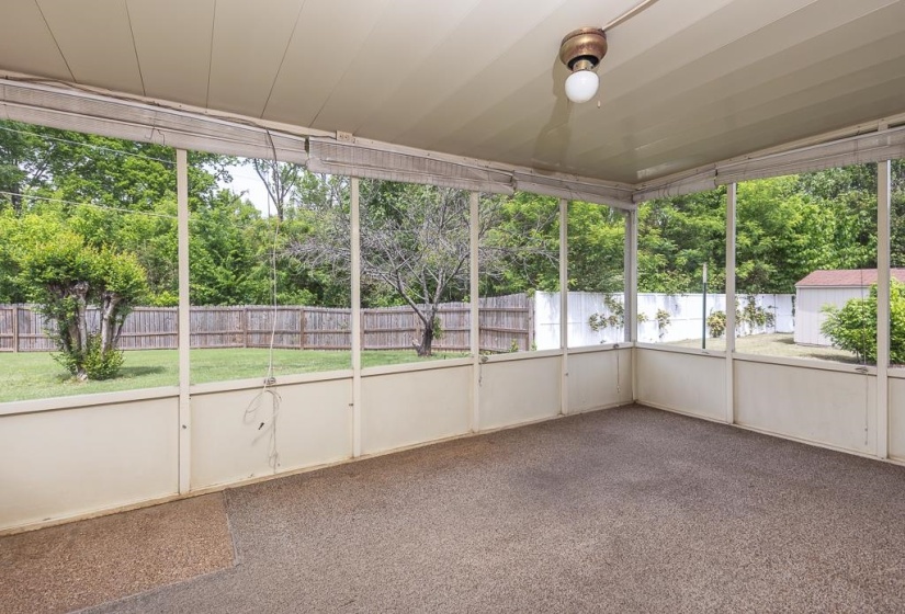 Screened-in patio with light brown carpeting and a ceiling-mounted light fixture