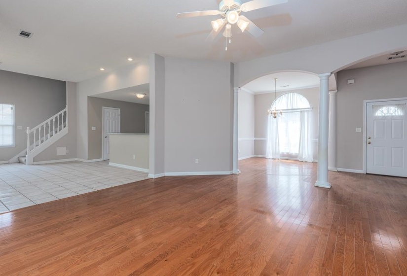 Spacious interior featuring wood-finish flooring, vaulted ceilings, and a decorative ceiling fan