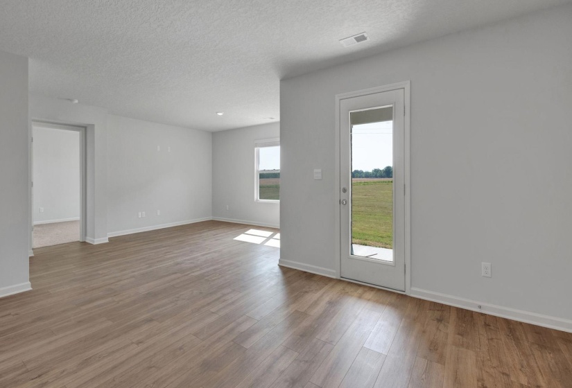 Expansive room featuring wood-finish flooring, light grey wall paint, and white trim
