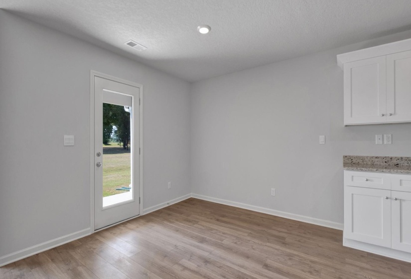 Interior space featuring light wood-finish flooring, white baseboards, and neutral wall paint