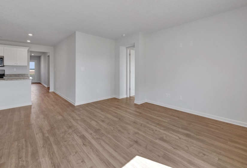 Open-concept living space featuring wood-finish flooring, recessed lighting, and a neutral color palette