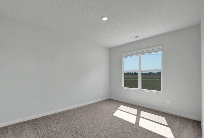 Spacious room with light neutral wall tones, recessed lighting, and soft carpet flooring