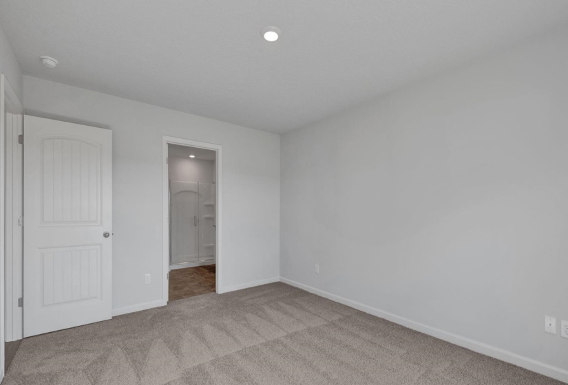 Neutral-toned carpeting and walls complement the white trim and doors