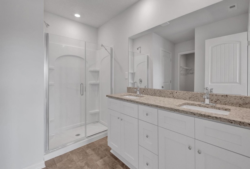 Double vanity featuring stone-finish countertops and two undermount sinks