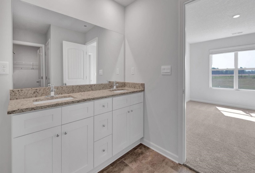 Dual vanity featuring white shaker cabinetry, integrated sinks, chrome fixtures, and a speckled countertop