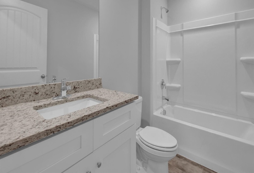 Bathroom featuring a white vanity with a light-toned speckled countertop, an undermount sink, and a chrome faucet