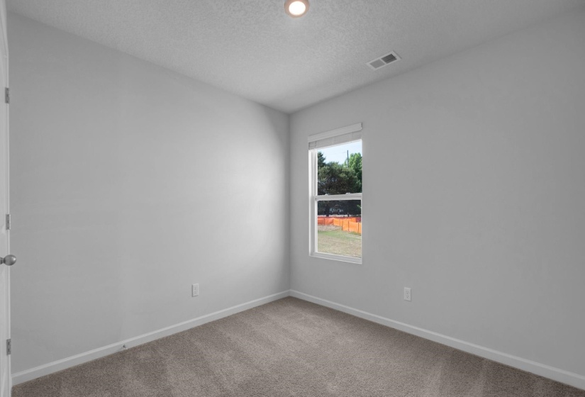 Neutral-toned room with plush carpeting, a single window with blinds, and white trim
