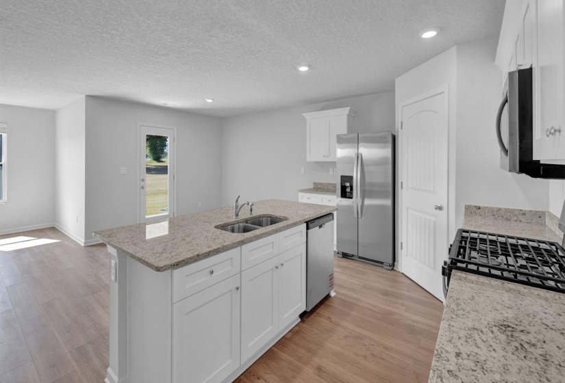 Kitchen island featuring a double-basin sink and light-toned countertop