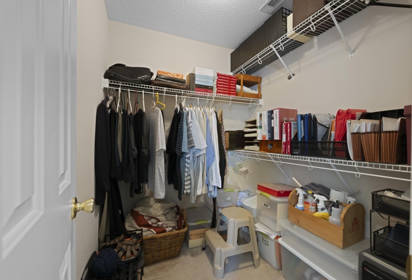 Walk-in closet featuring wire shelving, multiple hanging rods, and neutral wall paint