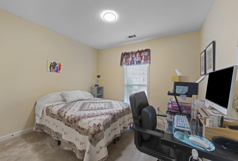 Bedroom featuring warm neutral wall tones and plush carpet flooring