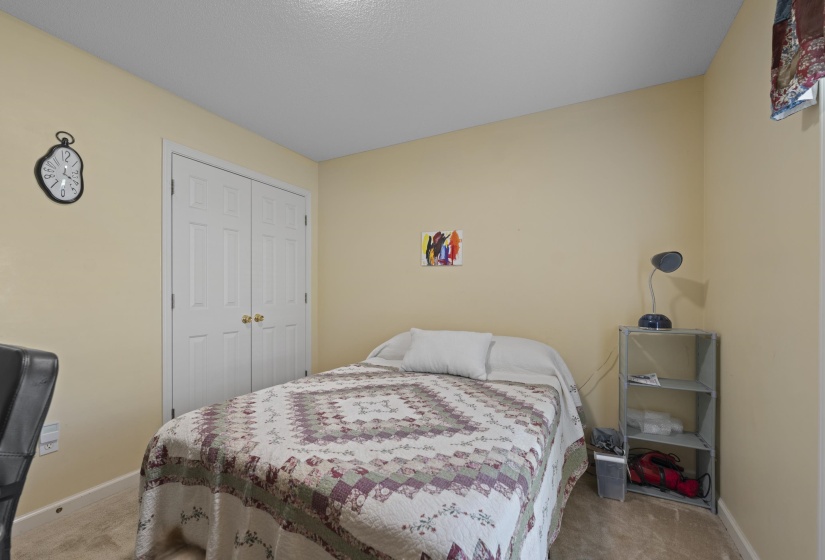 Bedroom featuring light-colored walls, carpeted flooring, and a ceiling with a textured finish