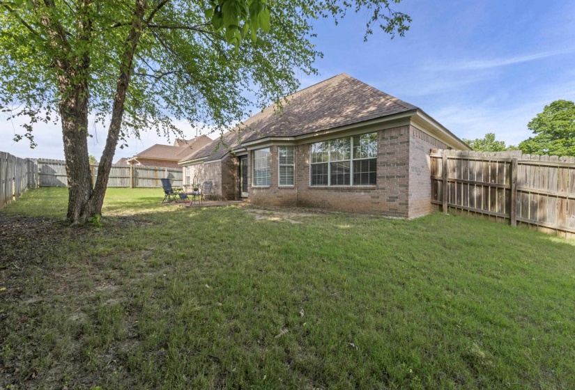 Private backyard featuring a full perimeter wooden fence and mature trees