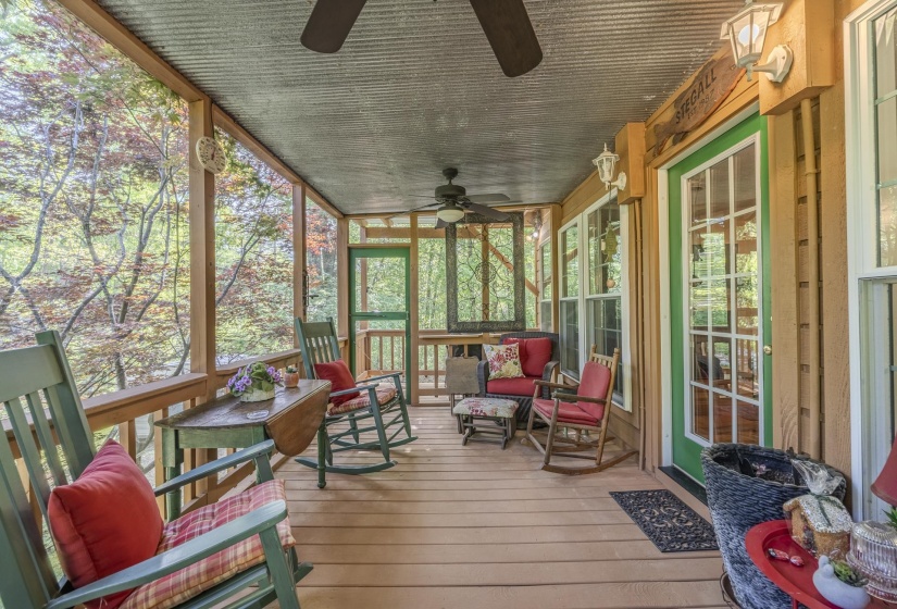 Screened porch featuring a corrugated metal ceiling, wood-finish flooring, and multiple ceiling fans