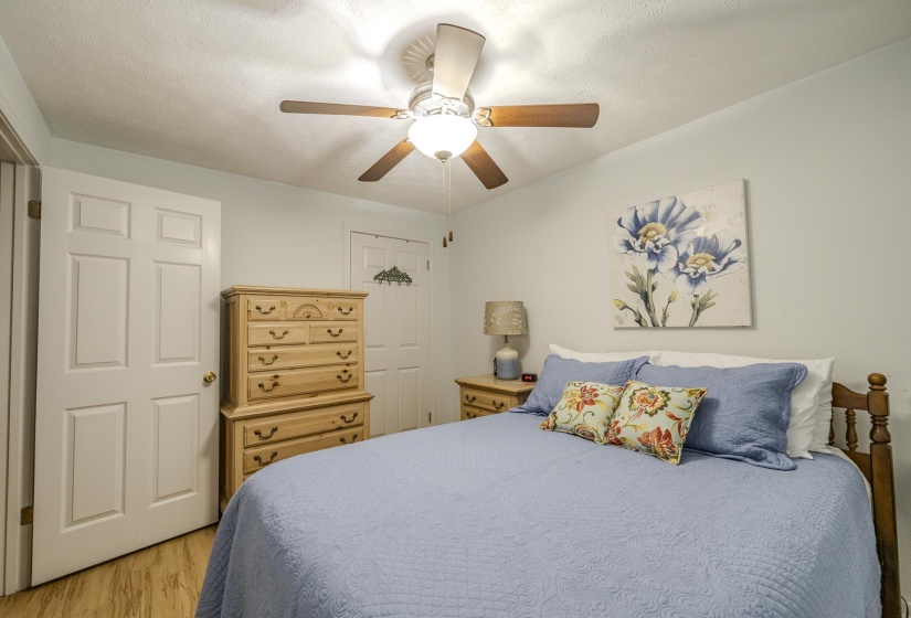 Recessed ceiling fan with light fixture, light-toned wood-finish flooring, and white paneled doors
