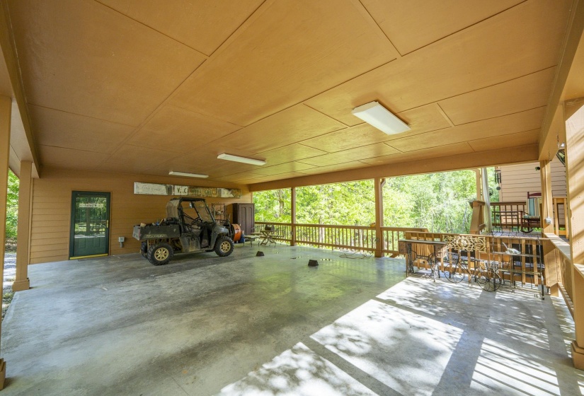 Expansive covered concrete patio featuring a wood-paneled ceiling, wood siding, and recessed lighting