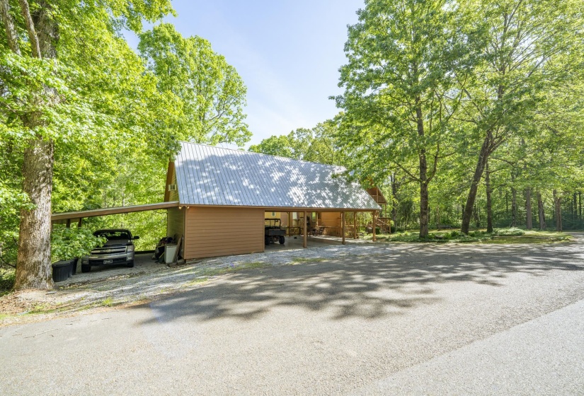 Wood-sided structure featuring a metal roof and an attached carport