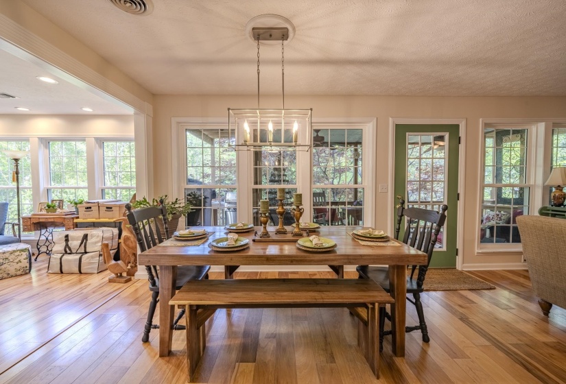 Dining area featuring wood-finish flooring, a rectangular wood dining table, and a linear chandelier