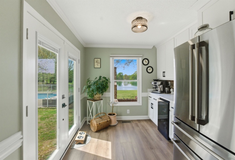 Kitchen featuring white cabinetry, stainless steel appliances, and wood-finish flooring