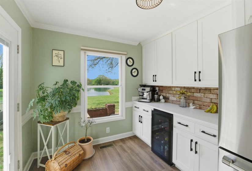 White cabinetry with dark hardware, brick backsplash, and light-tone countertops