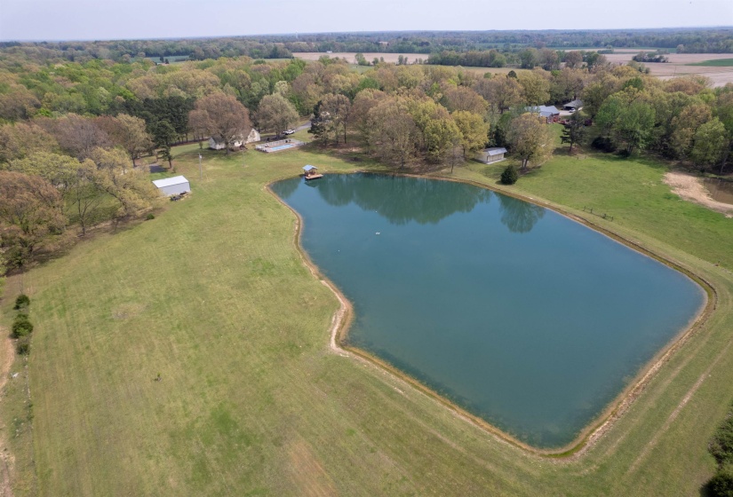 Expansive property featuring a large pond with a floating dock