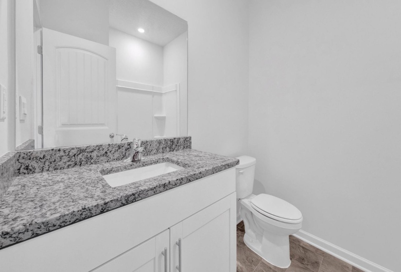 Bathroom vanity featuring a speckled countertop, integrated sink, and chrome faucet