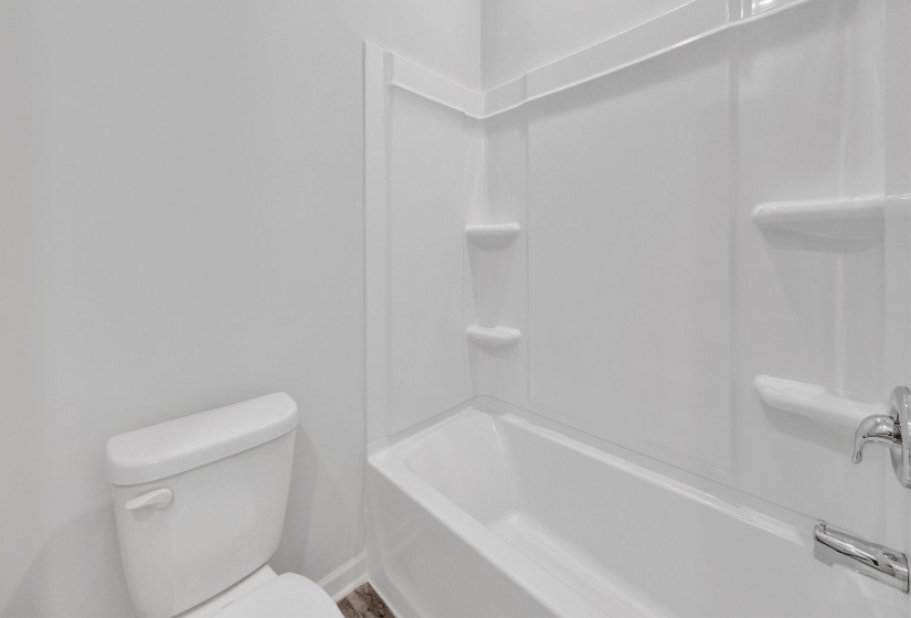 White tub-shower combination with integrated shelving