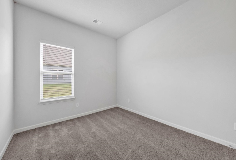 Neutral-toned interior room featuring light gray walls, white trim, and gray carpeting