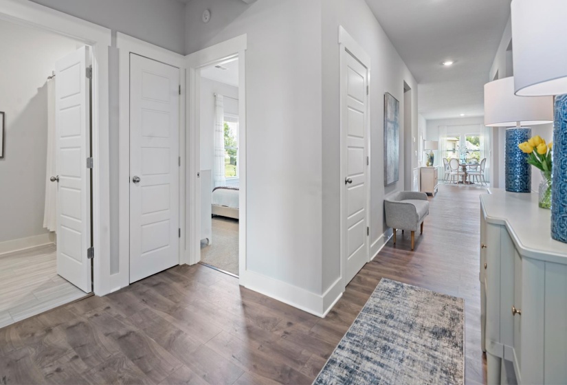 Hallway featuring wood-finish flooring, white paneled doors, and recessed lighting