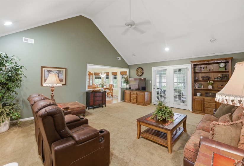 Spacious living area featuring a vaulted ceiling with a ceiling fan, recessed lighting, and soft green wall tones