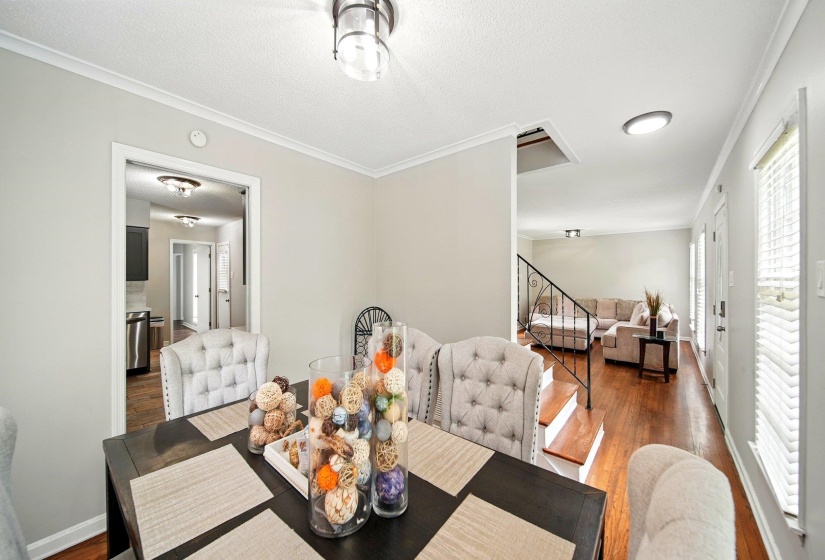 Dining area featuring crown molding, hardwood / wood-style floors, and a textured ceiling