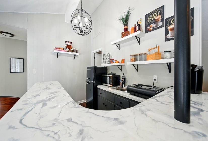 Bedroom featuring freestanding refrigerator and hanging lights