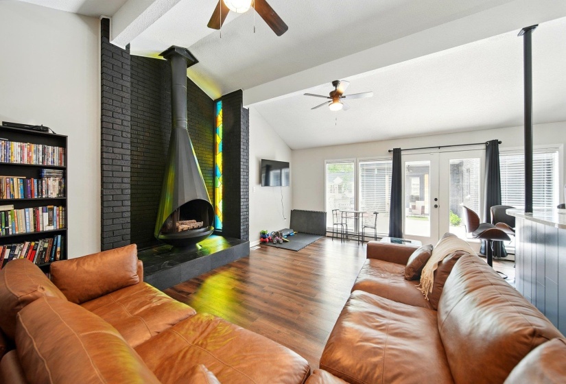 Living area with vaulted ceiling, wood finished floors, ceiling fan, and french doors