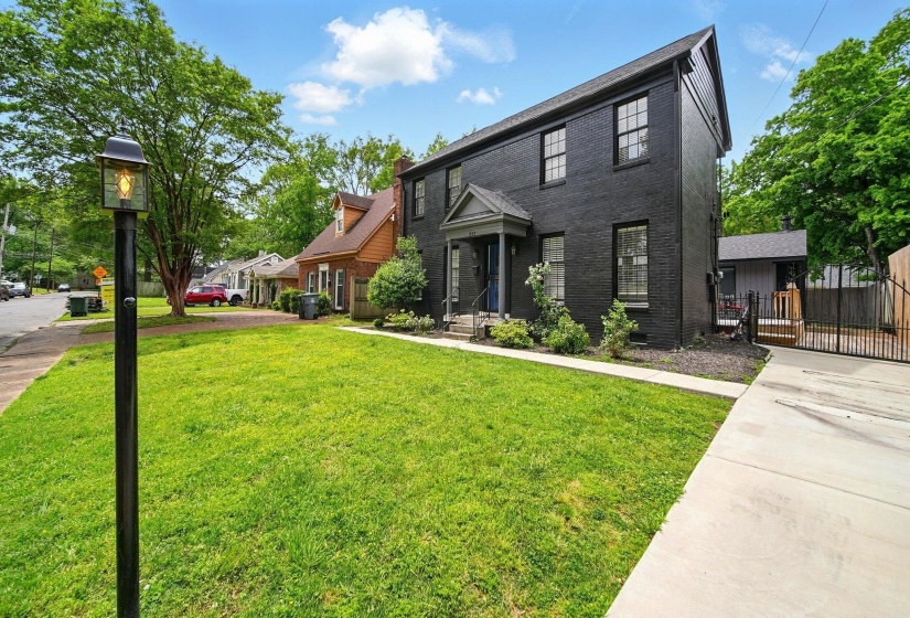 View of front facade featuring brick siding and a gate