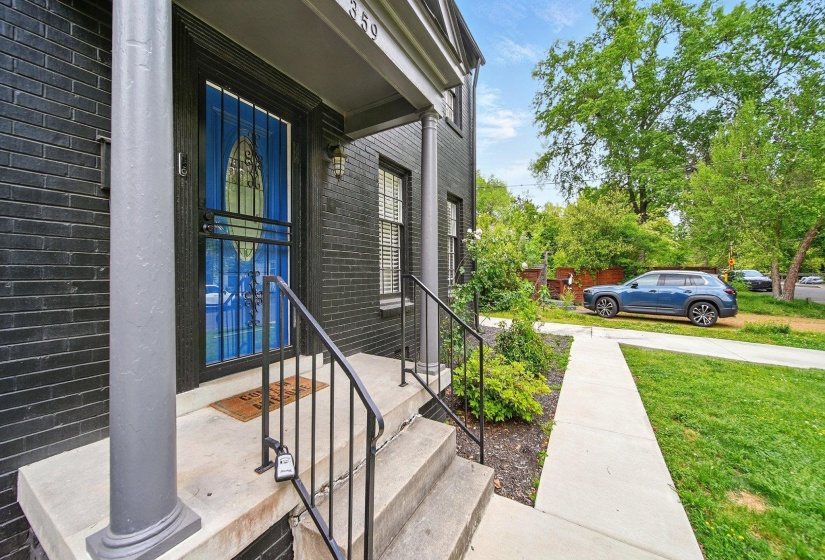 Property entrance featuring brick siding and a lawn