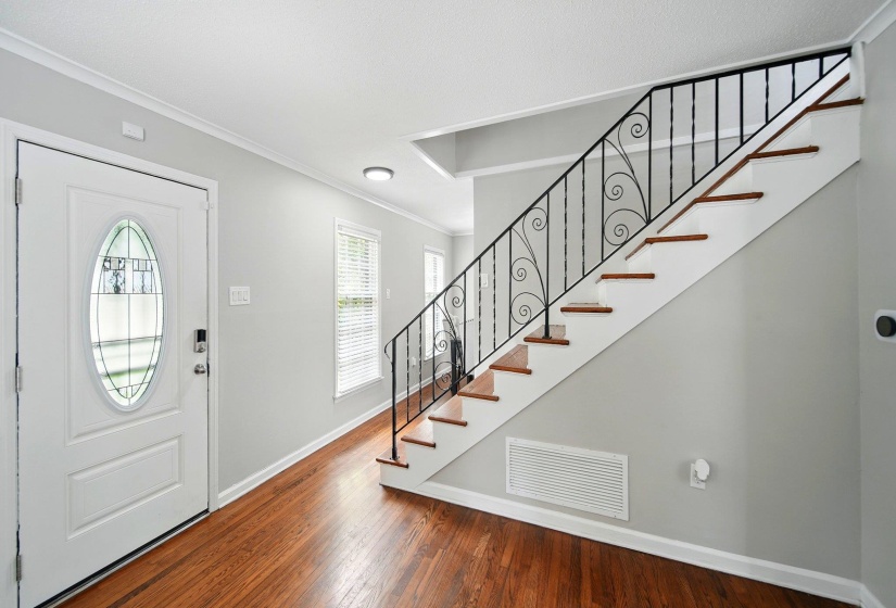 Foyer featuring crown molding and dark wood finished floors