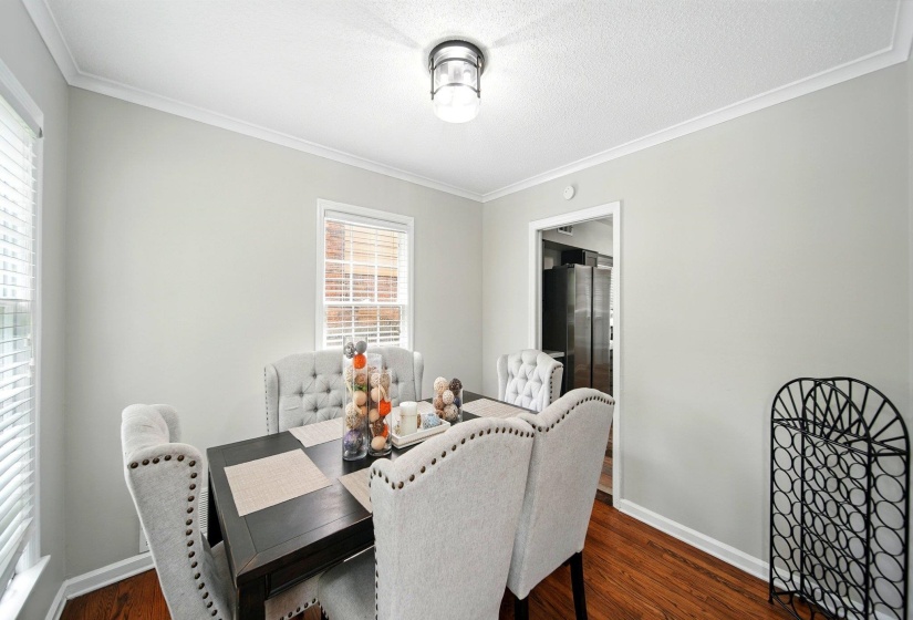 Dining space featuring crown molding, dark wood-type flooring, and a textured ceiling