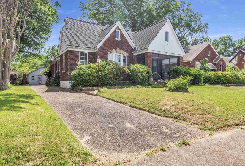 Brick residence featuring a gabled roofline, bay window, and a screened front porch