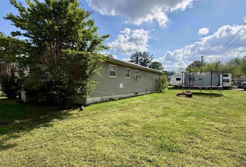Side exterior of the property featuring horizontal siding and multiple windows