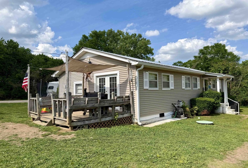 Exterior featuring light-colored siding and a metal roof