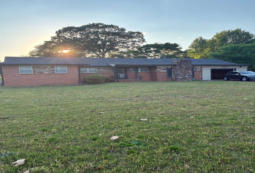 Brick and stone facade residence featuring a prominent stone chimney