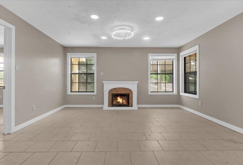 Living space featuring a white mantel fireplace, recessed lighting, and a decorative ceiling fixture
