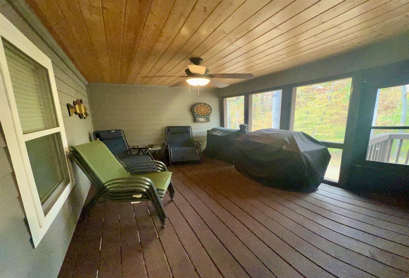 Sunroom / solarium featuring wood-type flooring, wood ceiling, a ceiling fan, and a wooden deck