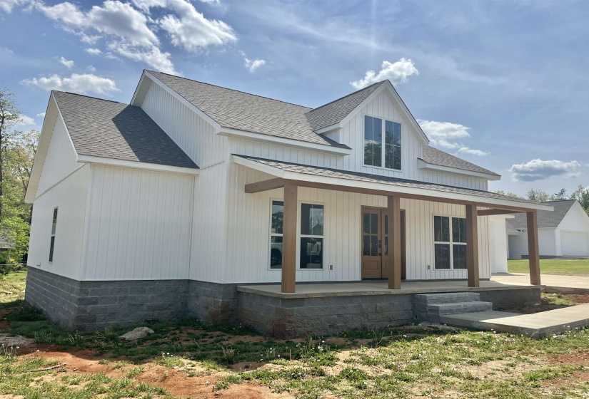 View of front of property with roof with shingles, covered porch, and board and batten siding
