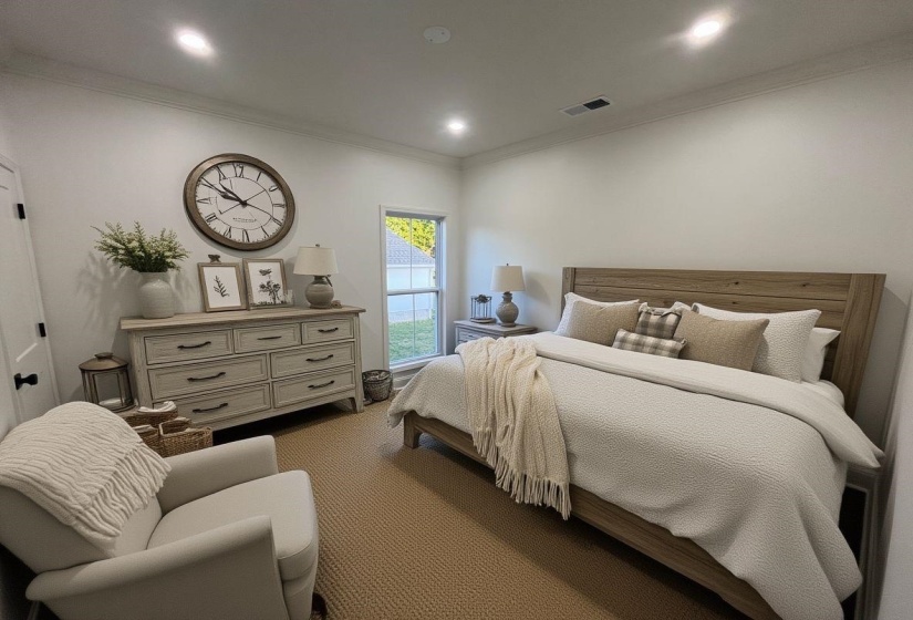 Recessed lighting illuminates a neutral-toned room featuring crown molding and a window providing natural illumination
