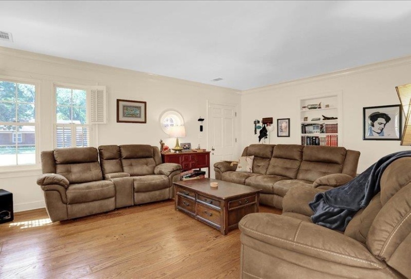 Living area featuring wood flooring, crown molding, and recessed built-in shelving and .... of course mid-town charm.